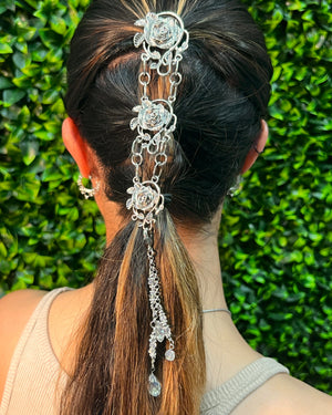 Silver Rose Hair Armor ponytail holder worn in a half-up hairstyle, featuring rose accents, decorative chains, and crystal drops, back view on model.