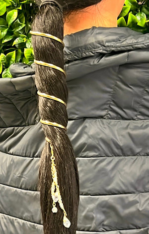 Model wearing a 6-inch gold spiral ponytail holder wrapped around a long ponytail, decorative metal hair accessory with dangling crystal charms, shown from the back.