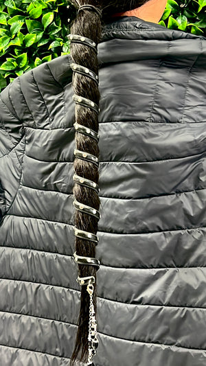 12-inch black leather spiral ponytail wrap with rivets worn on long dark hair, outdoor setting