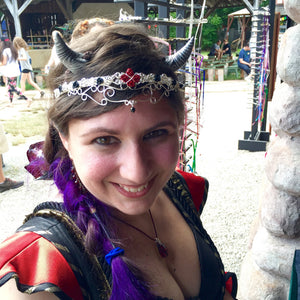 model wearing silver wire floral crown with red roses and crystal drop at renaissance fair