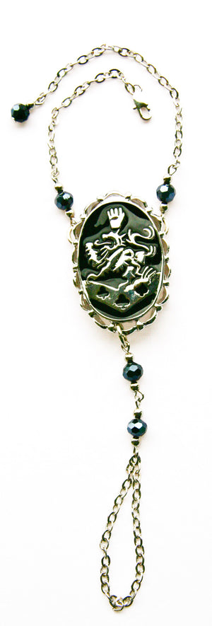 Kingdom crest gold-tone finger bracelet with chain, symbolic festival jewelry, front view on white background