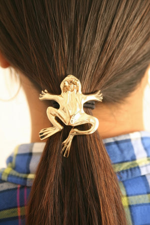 Gold frog ponytail hair hook securing ponytail, back view