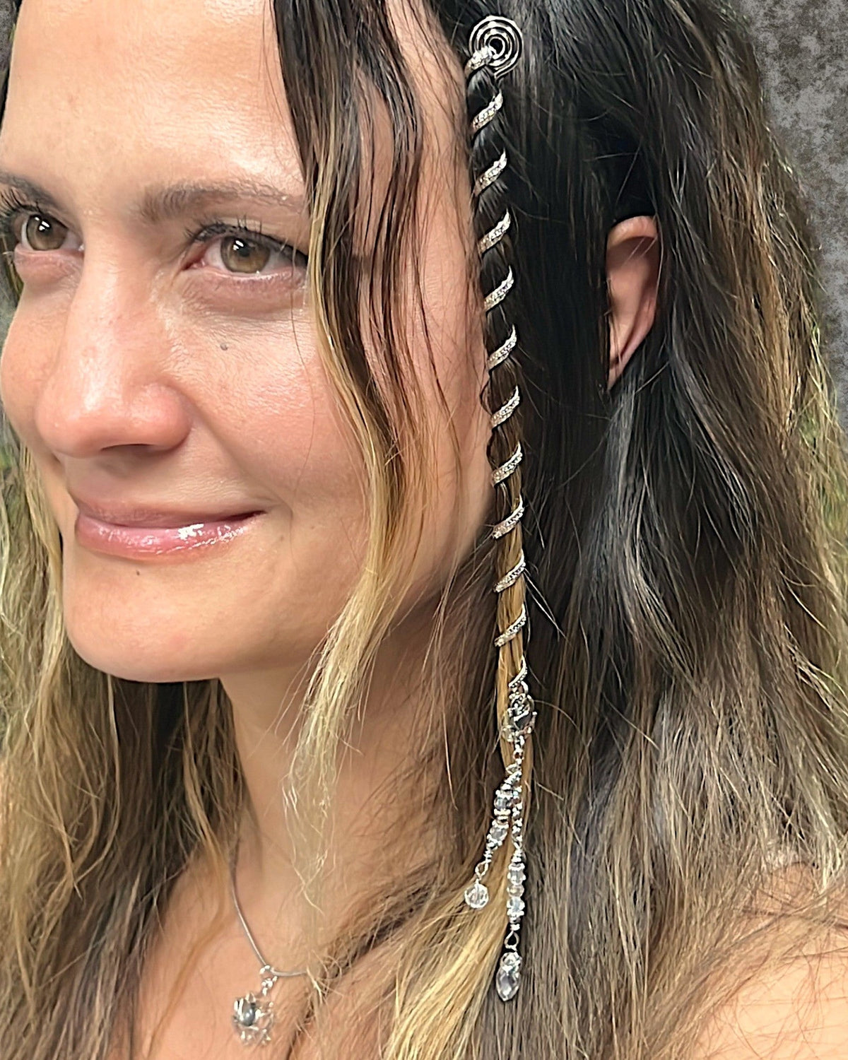 Model wearing a 6 inch silver Hair Twister in long hair with dangling crystal charms.