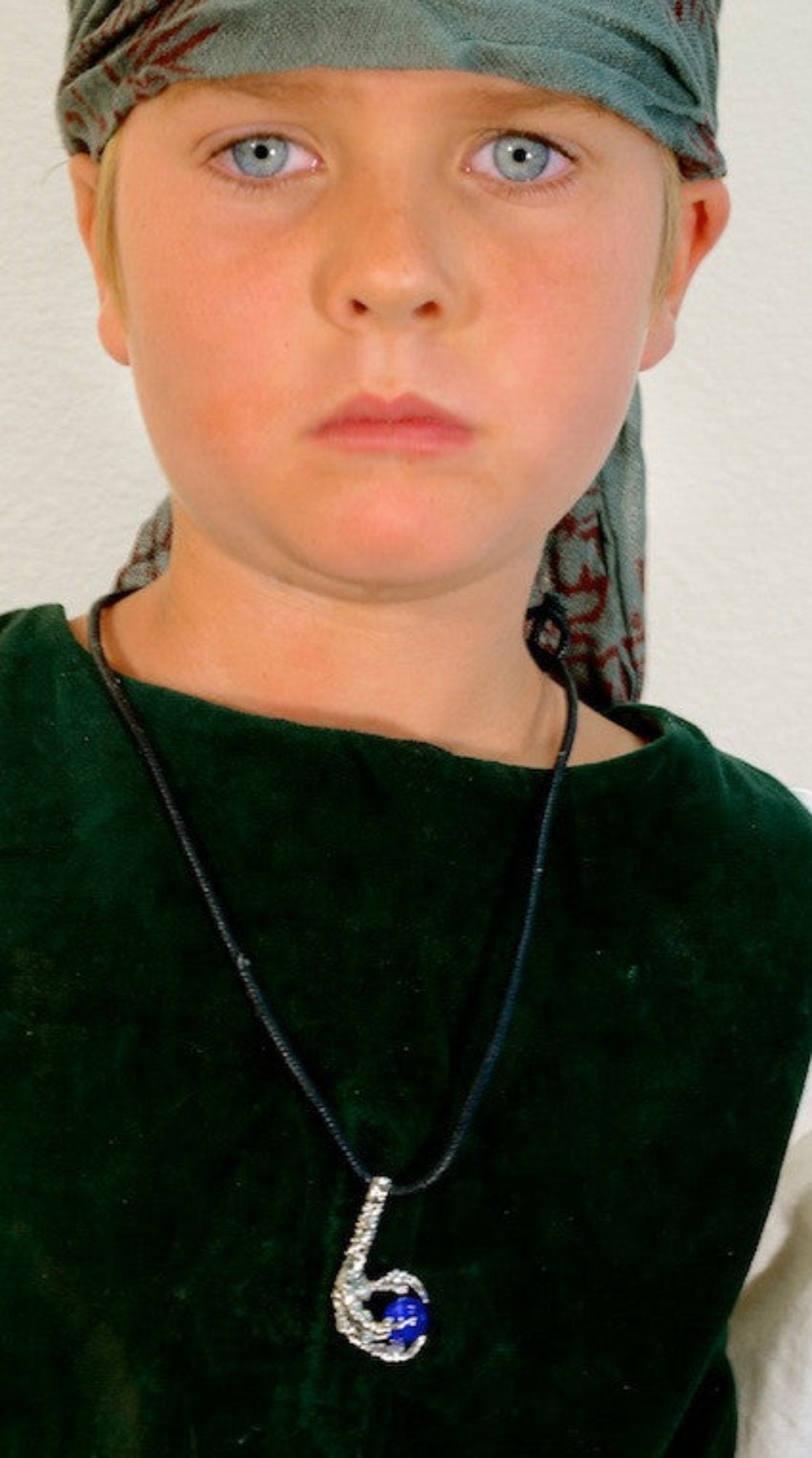 Model wearing silver bird claw necklace with blue gemstone pendant on black cord, inspired by Celtic and fantasy jewelry