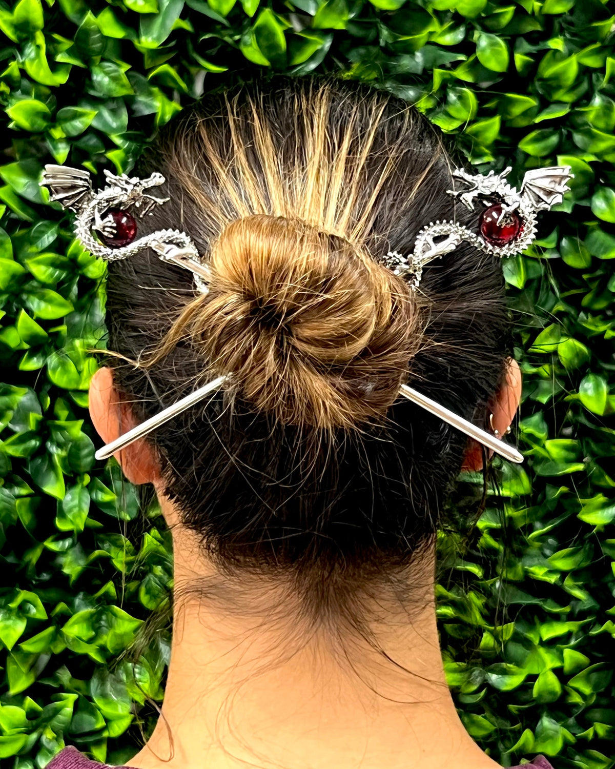 Model wearing Silver Dragon Hair Sticks with 3D dragons holding red crystal spheres in a twisted bun hairstyle.