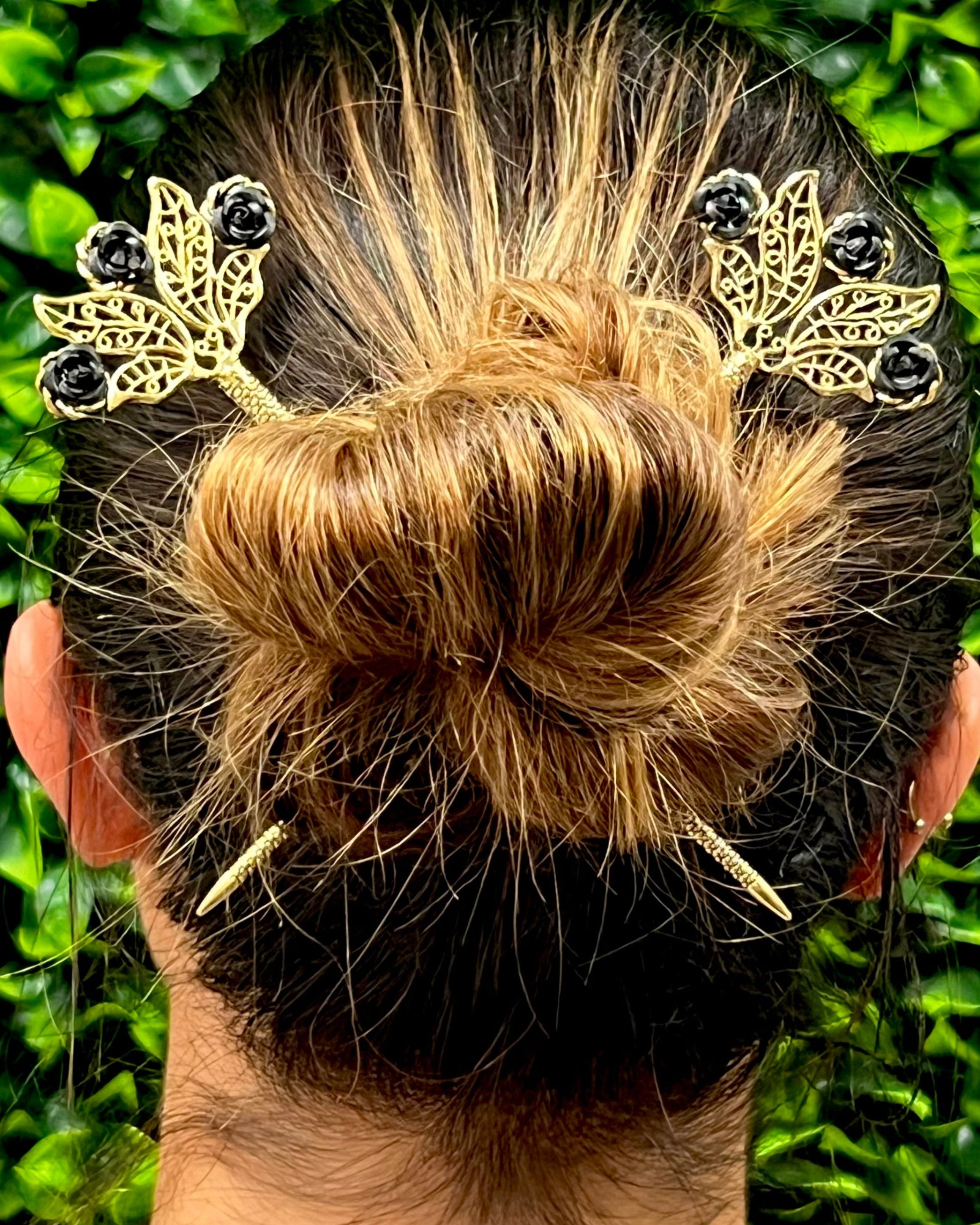 Model wearing Floral Fan Hair Sticks – Gold floral fan hair sticks with black rose accents styled in a bun hairstyle.