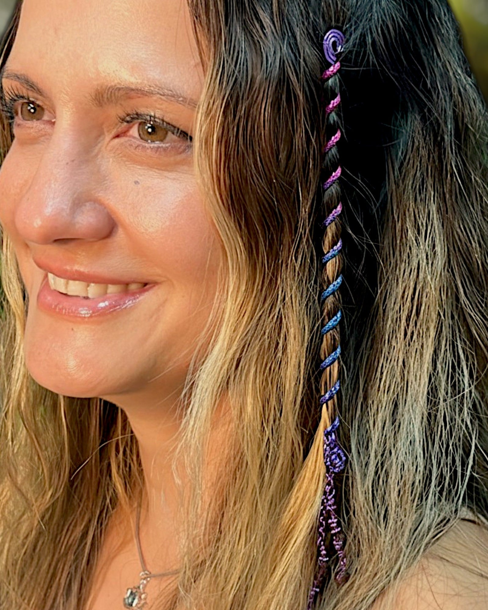 Close-up of a 6-inch rainbow Hair Twister spiral hair accessory with purple bead charm, worn in long wavy hair.