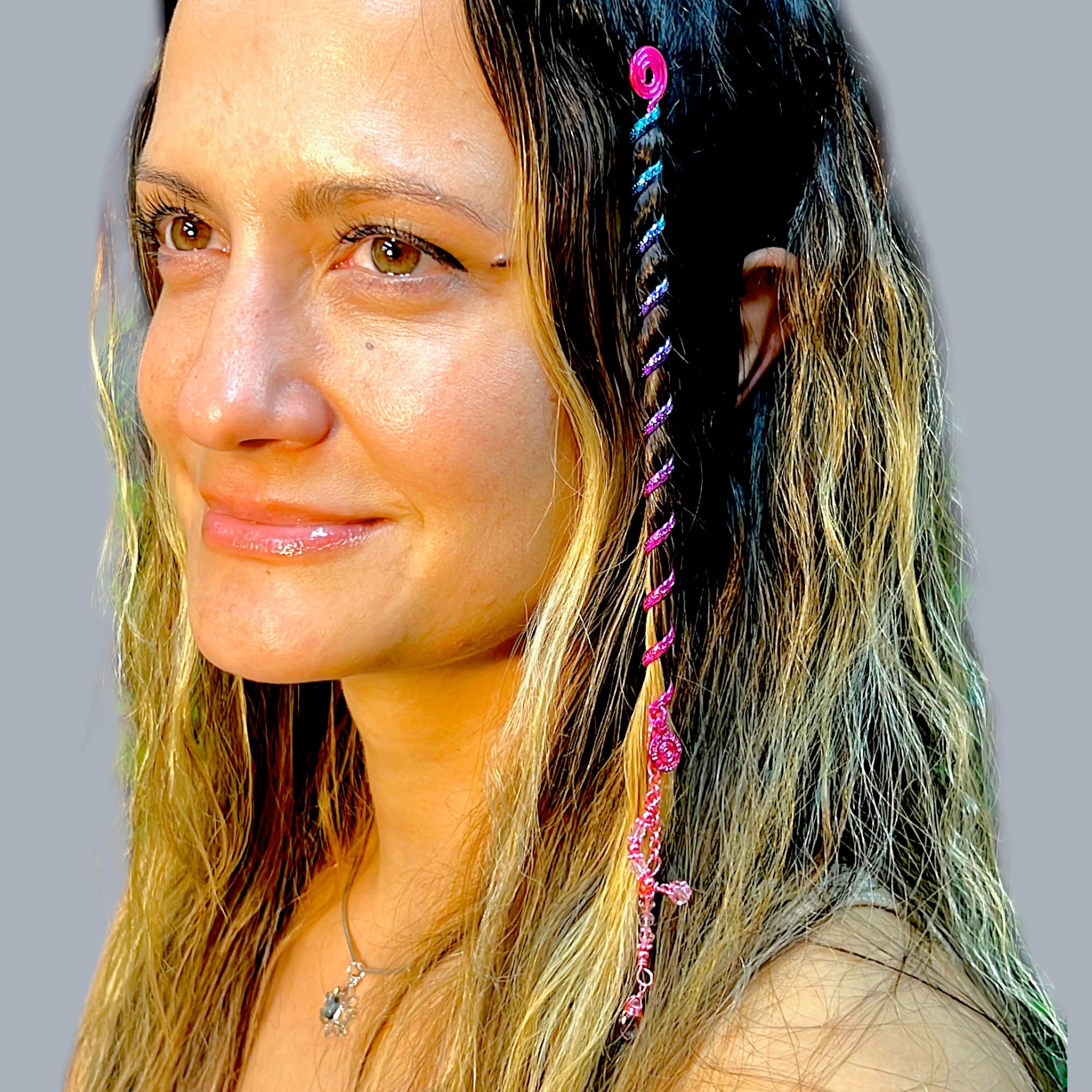 6 inch pink hair twister in long wavy blonde hair, metal spiral hair accessory styled in braid with dangling charm, side profile