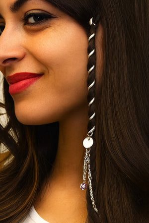 Woman wearing a 4-inch silver Hair Twister spiral hair wrap with dangling charm accent, securing a section of hair for a boho-inspired hairstyle, side view.