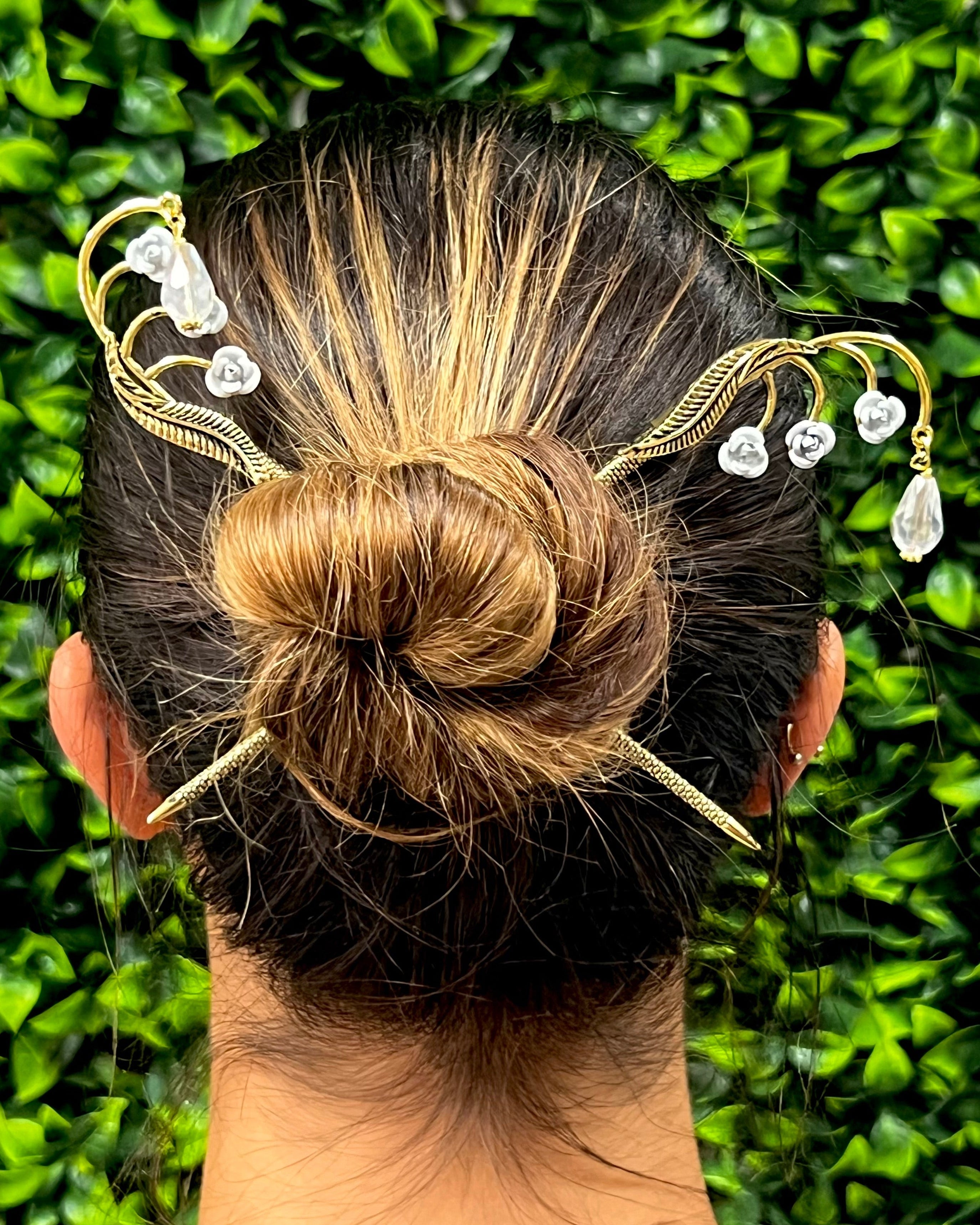Model wearing Leafy Flower Gems Hair Sticks in a bun hairstyle, rear view with gold leafy branches, clear crystal flowers, and dangling crystal drops.