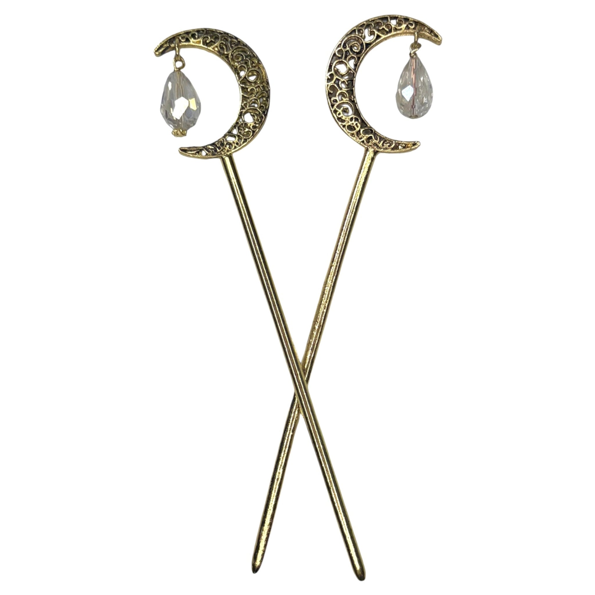 Pair of antique gold crescent moon hair sticks with clear crystal teardrop dangles, shown crossed on a white background to display the front view and celestial moon design.