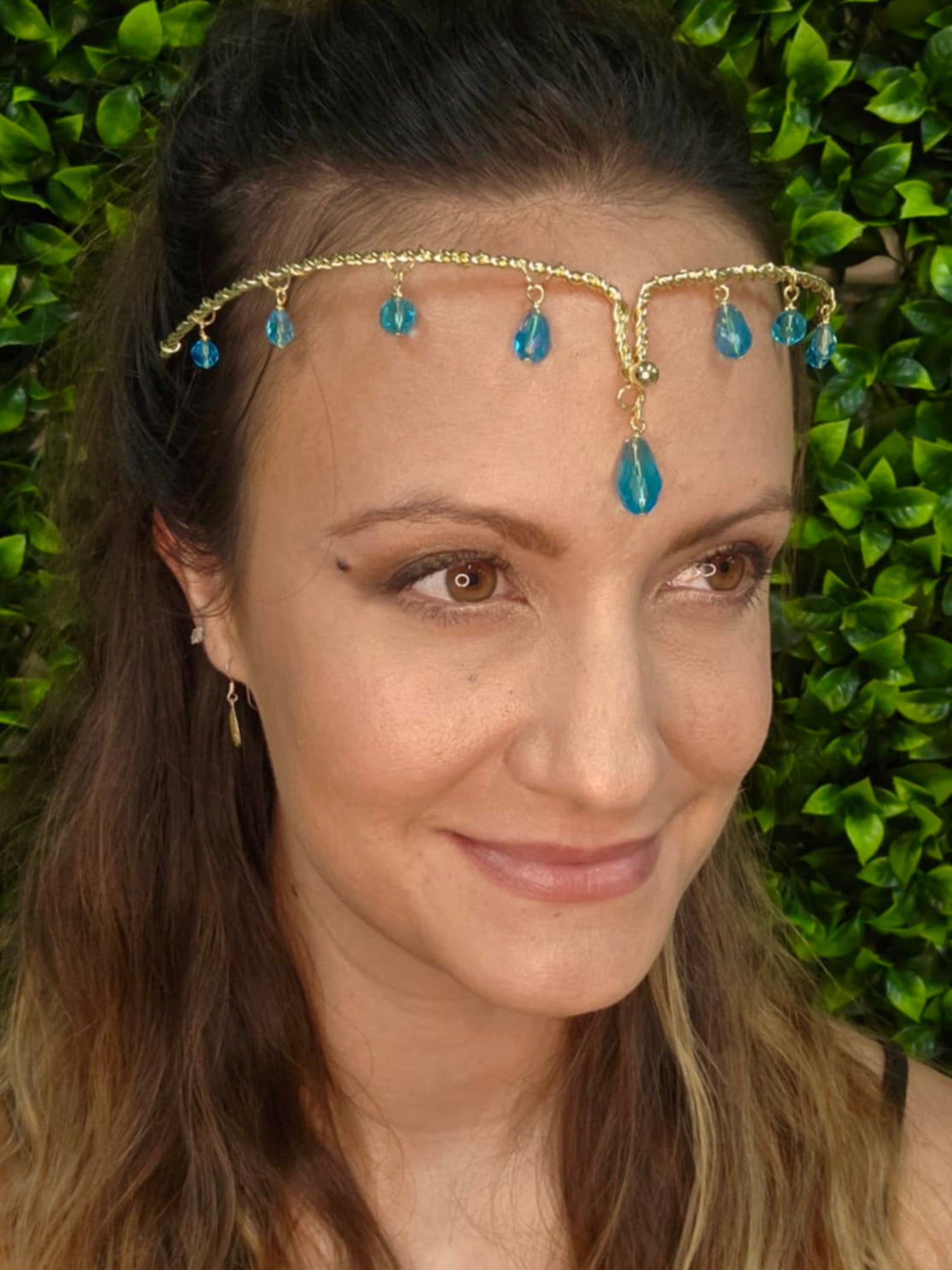 Gold wire forehead band with blue crystal drop accents worn on head