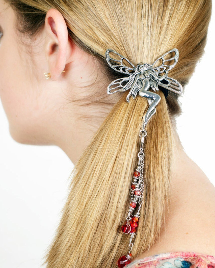 Side view of a model wearing a silver Tinkerbell hair hook with dangling red bead charms securing a ponytail.
