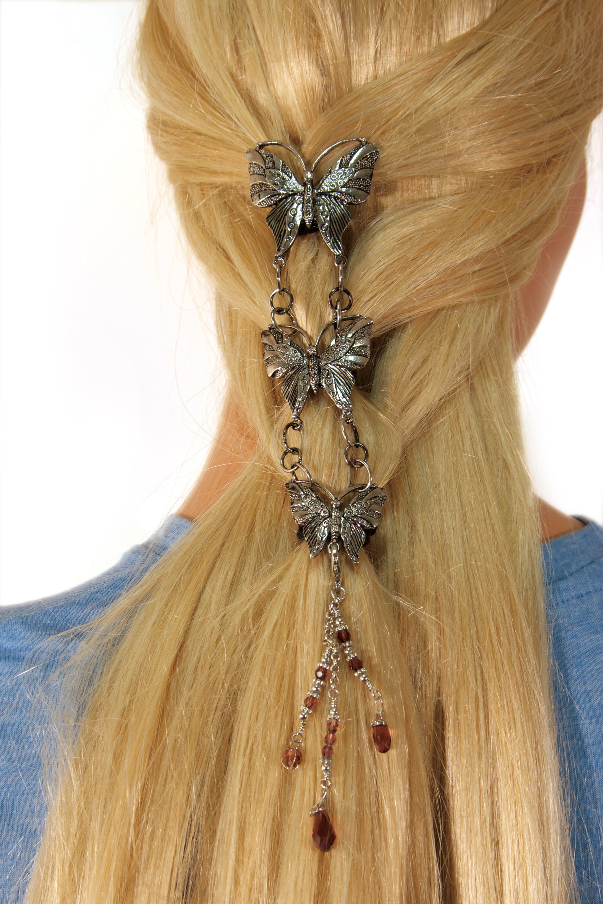 Model demonstrating installation of Silver Butterfly Hair Armor hair accessory in long hair ponytail