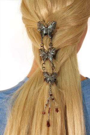 Model demonstrating installation of Silver Butterfly Hair Armor hair accessory in long hair ponytail