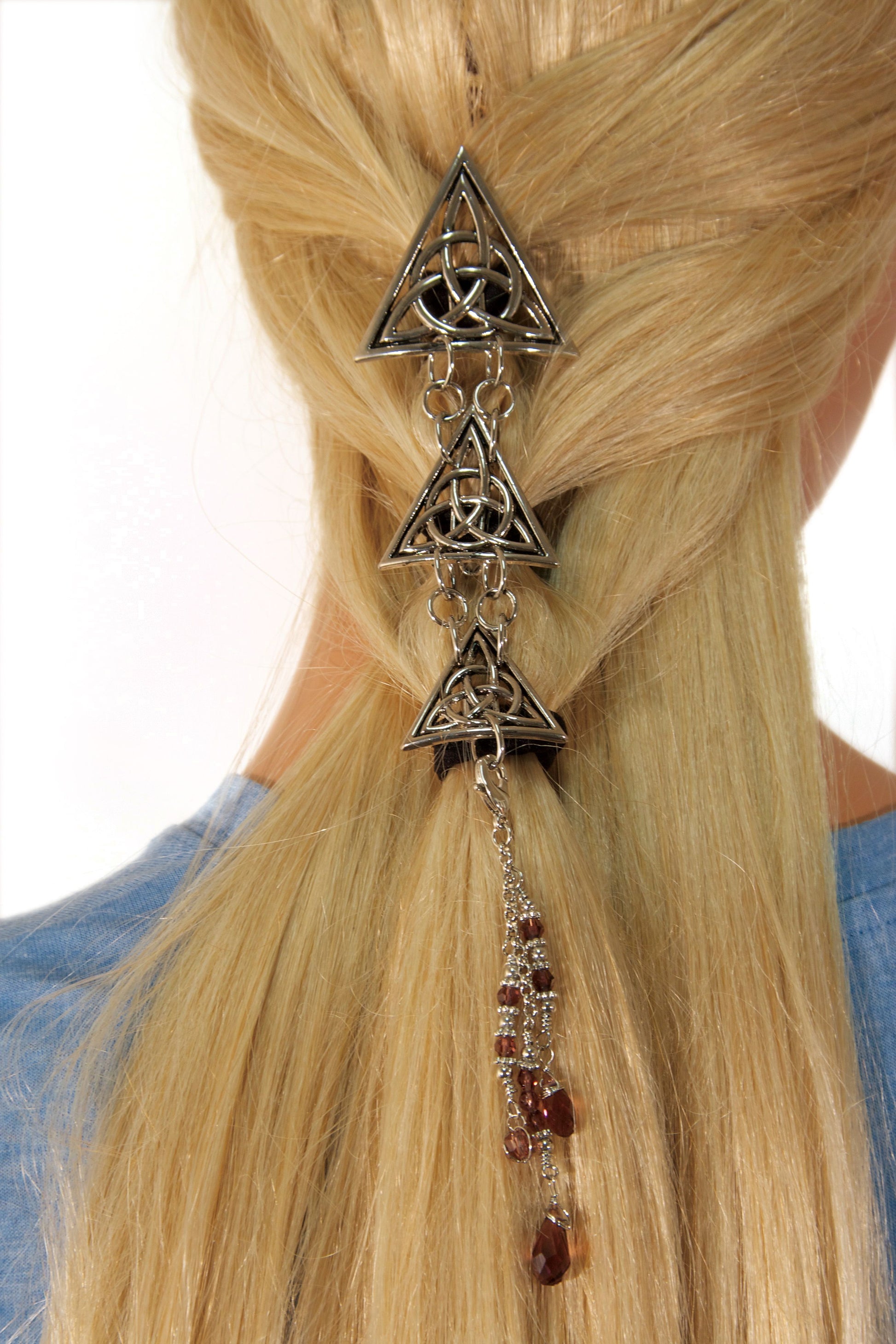 Model demonstrating installation of Silver Celtic Triangle Hair Armor in long ponytail hairstyle
