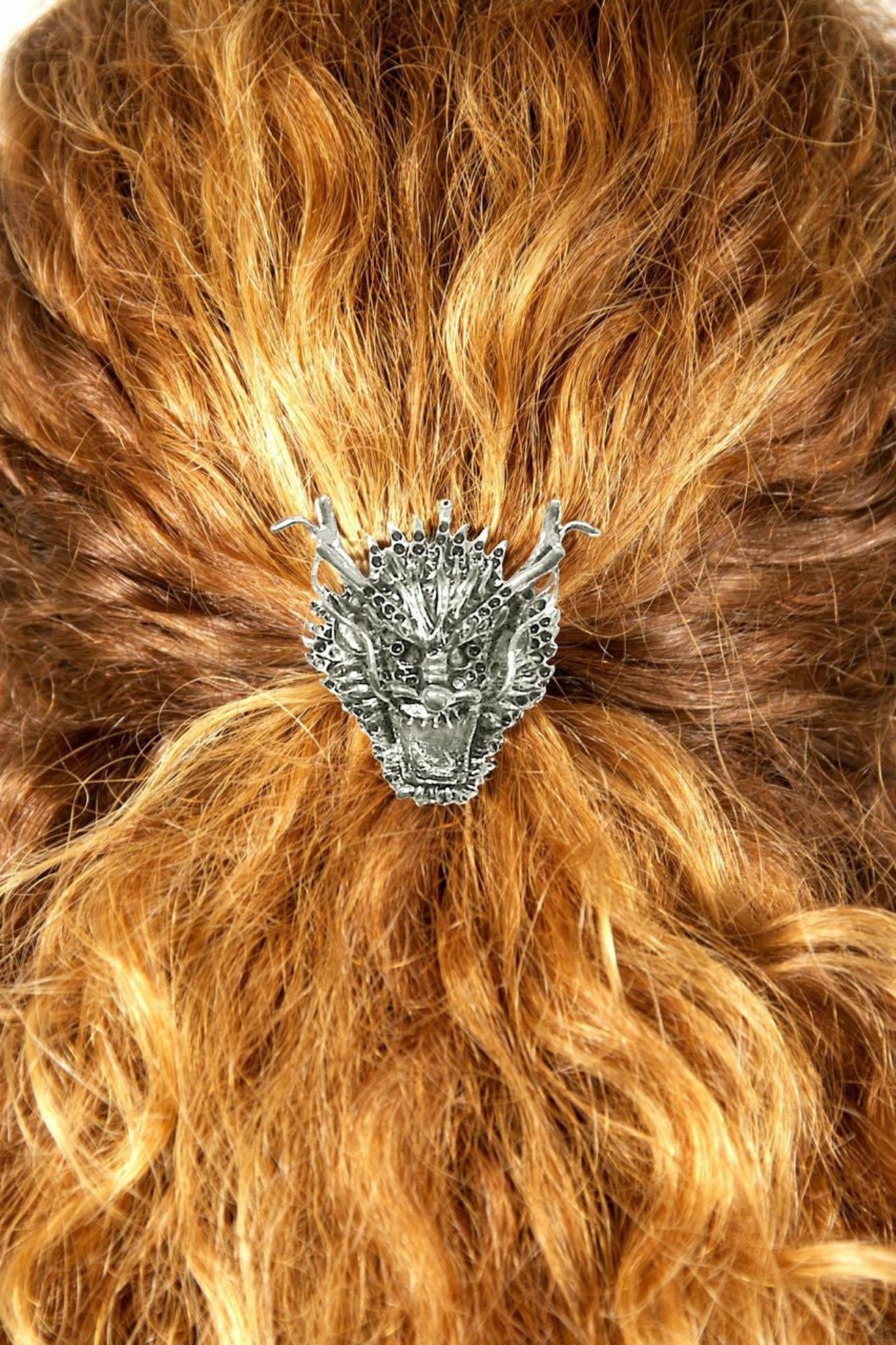 Silver dragon hair hook ponytail holder worn in curly red hair, back view