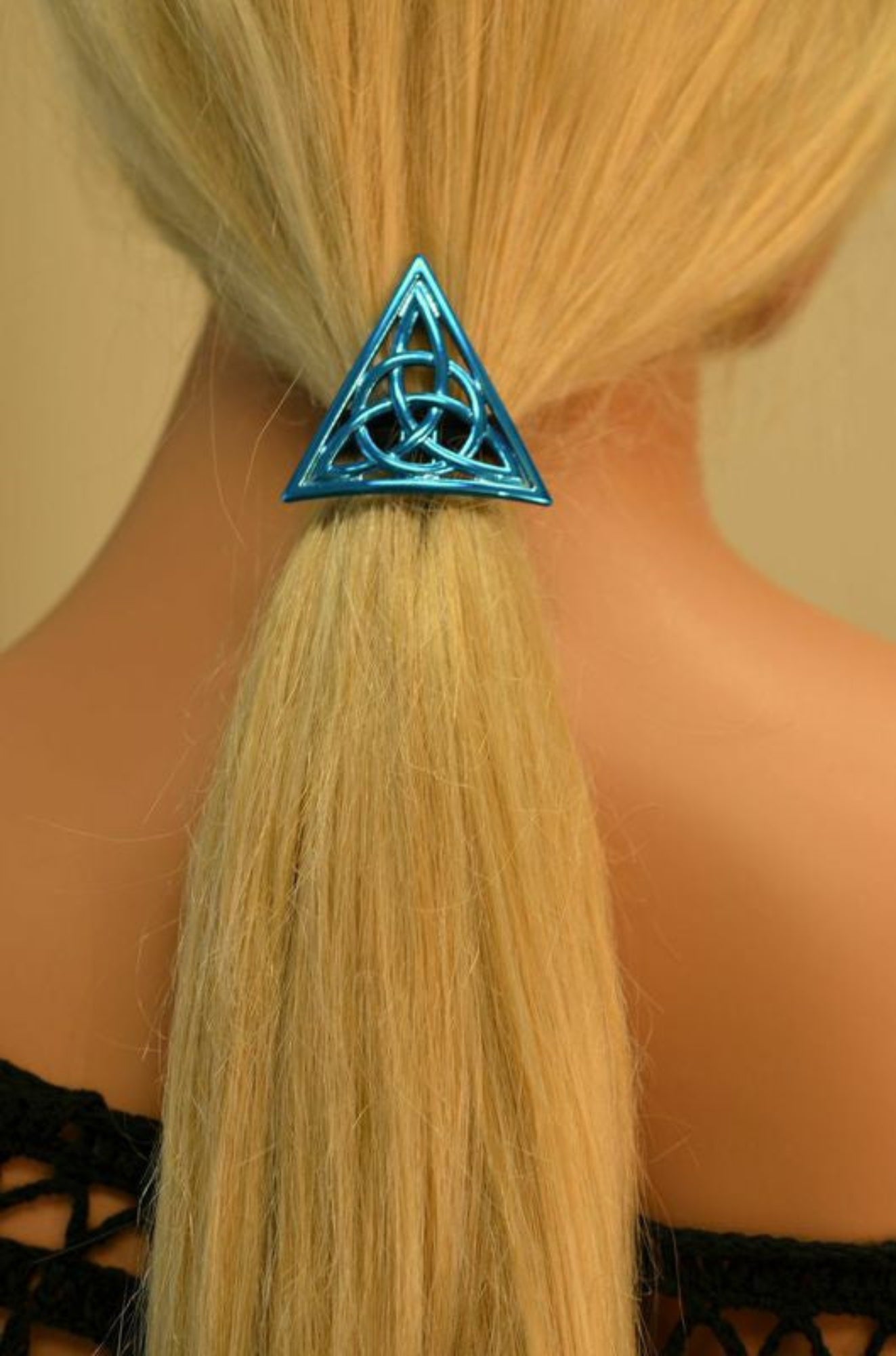 Blue Celtic triangle hair hook securing ponytail, back view