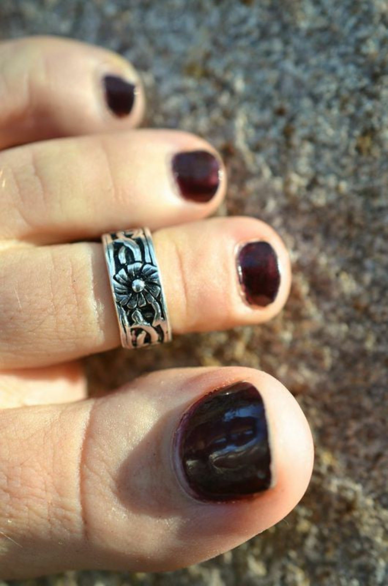 Model wearing antique flower toe ring in silver, adjustable