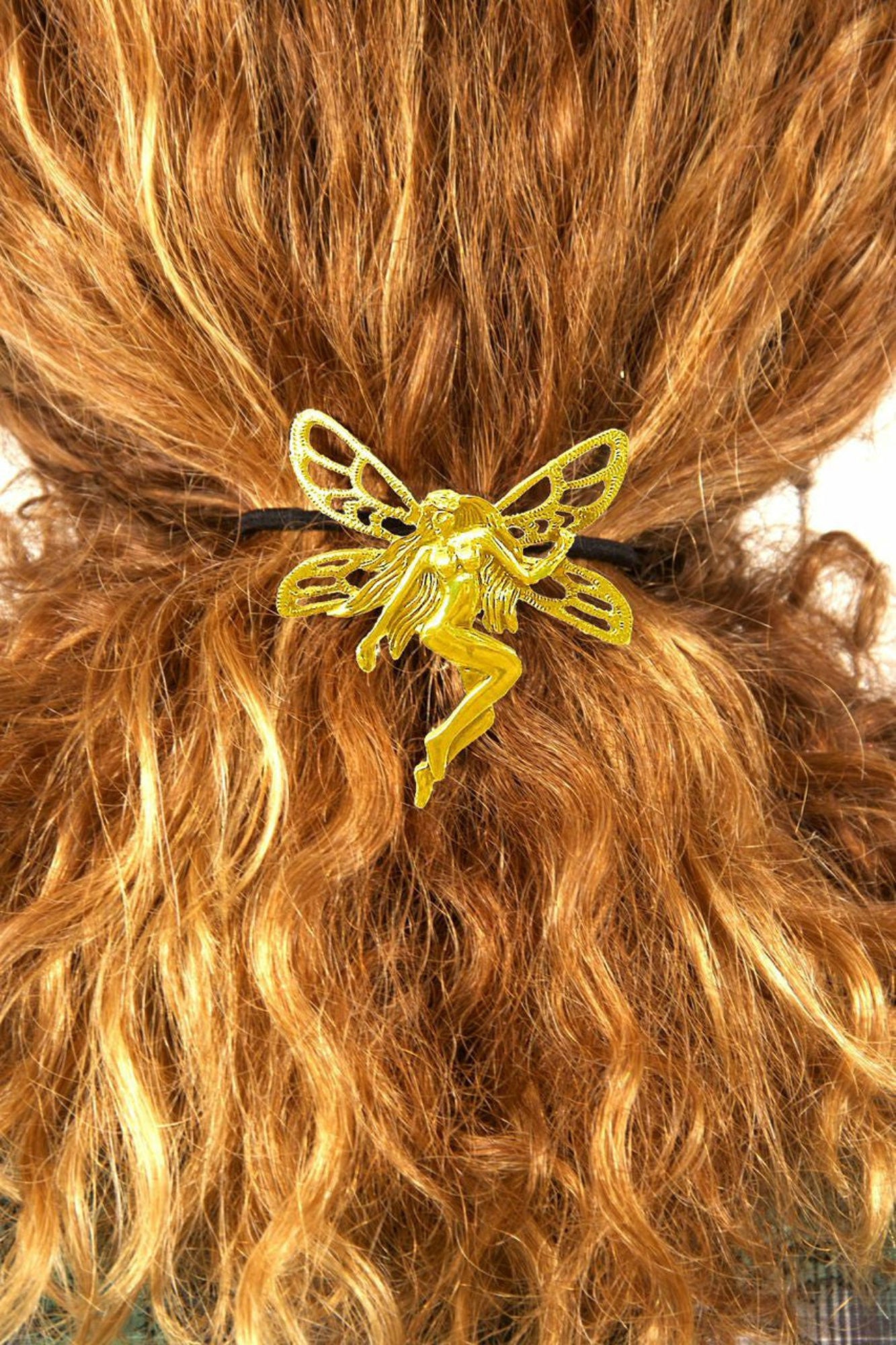 Gold winged fairy hair hook securing ponytail, back view