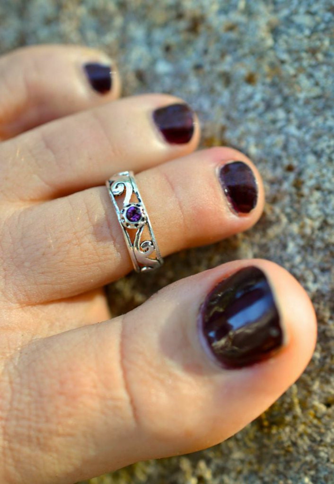 Model wearing spiral band toe ring, silver overlay, adjustable, with purple stone