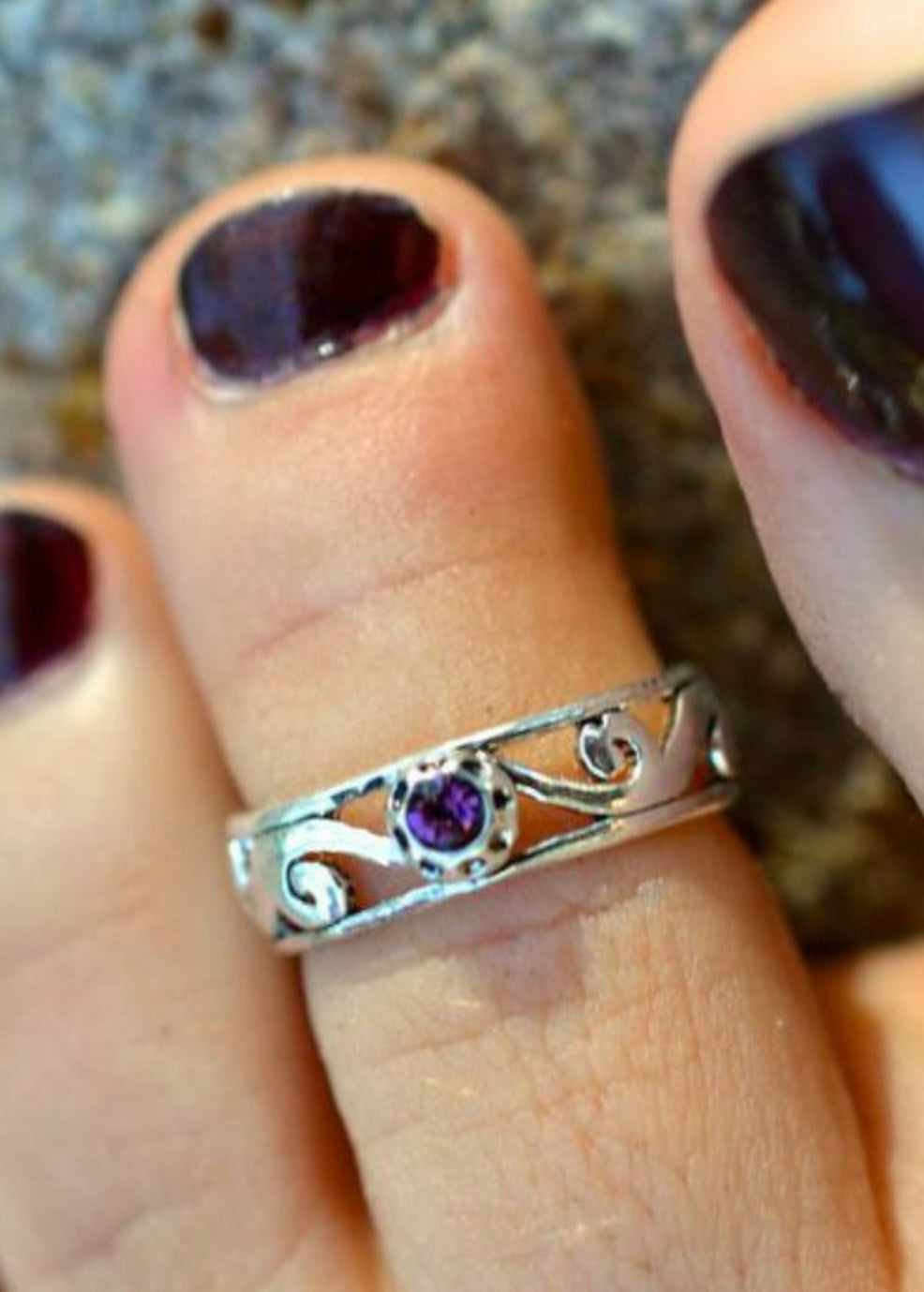 Model wearing spiral band toe ring, silver overlay, adjustable, with purple stone