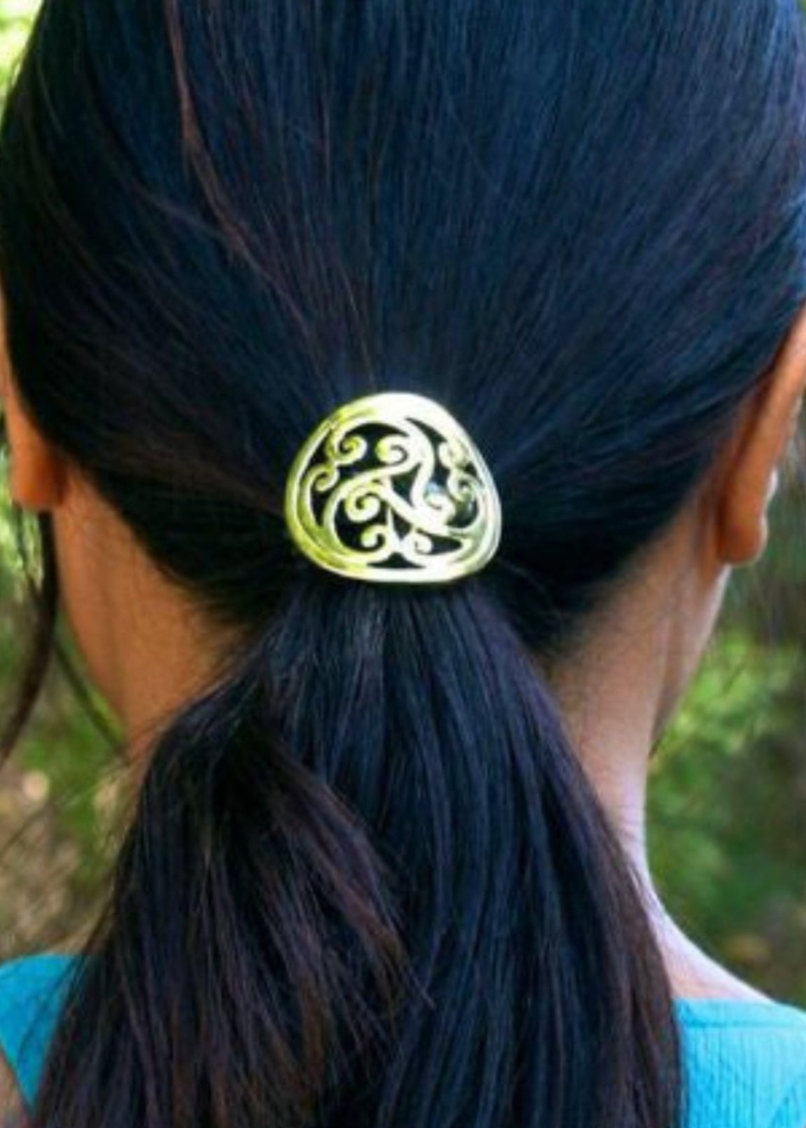 Model wearing gold Celtic swirl hair hook in ponytail outdoors