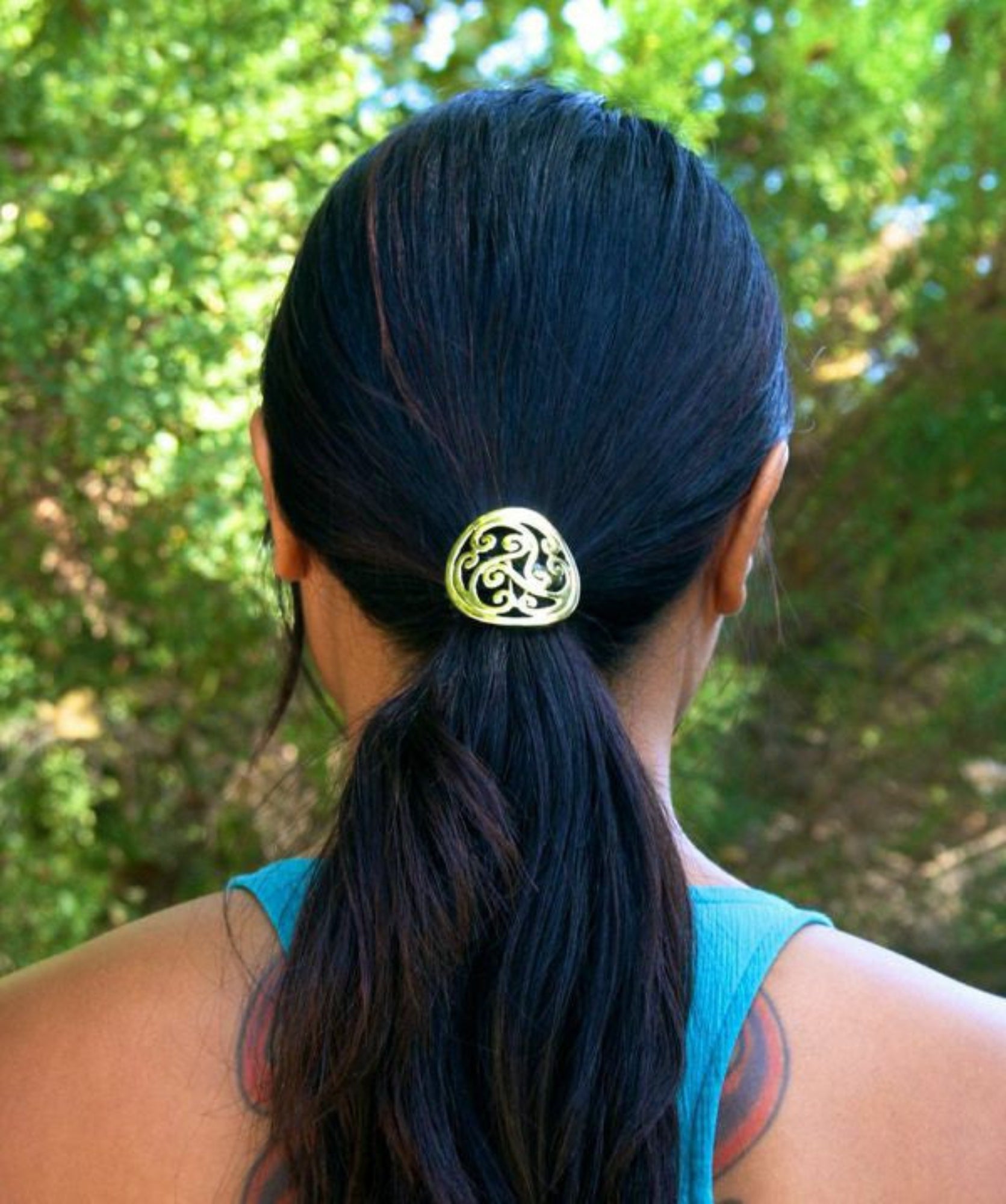 Model wearing gold Celtic swirl hair hook in ponytail outdoors