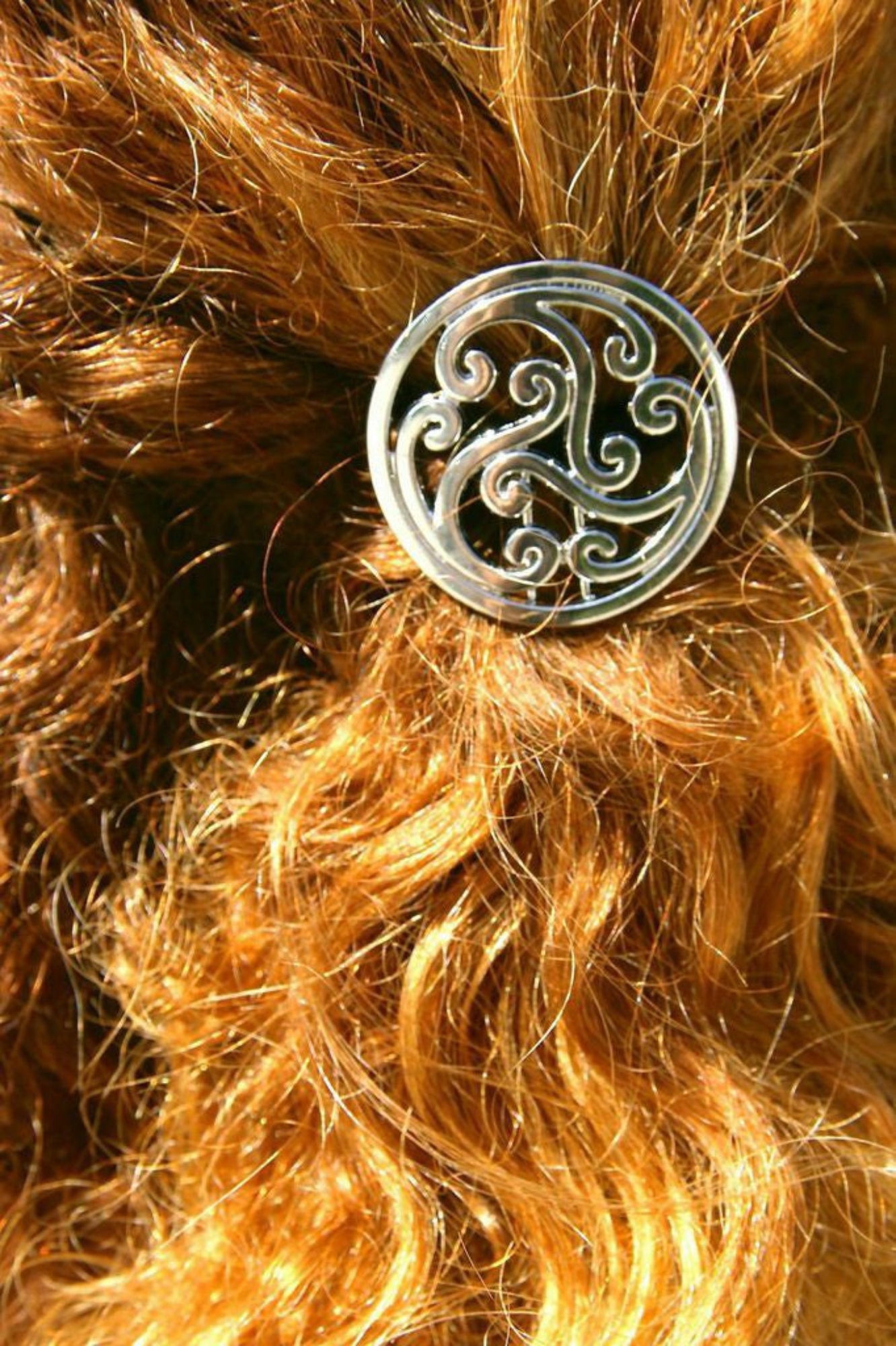 Woman wearing silver Celtic knot hair hook in curly ponytail