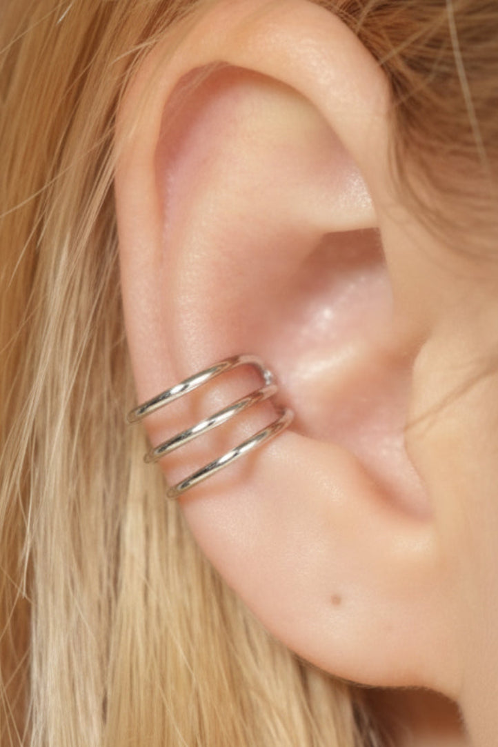 Silver triple strand ear cuff worn on ear, adjustable non-piercing design, side view