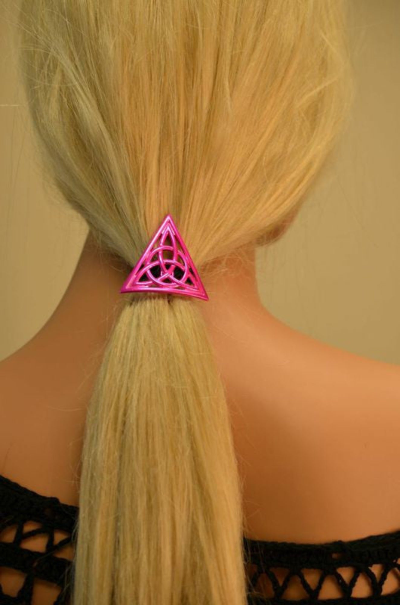 Pink Celtic triangle hair hook securing ponytail, back view
