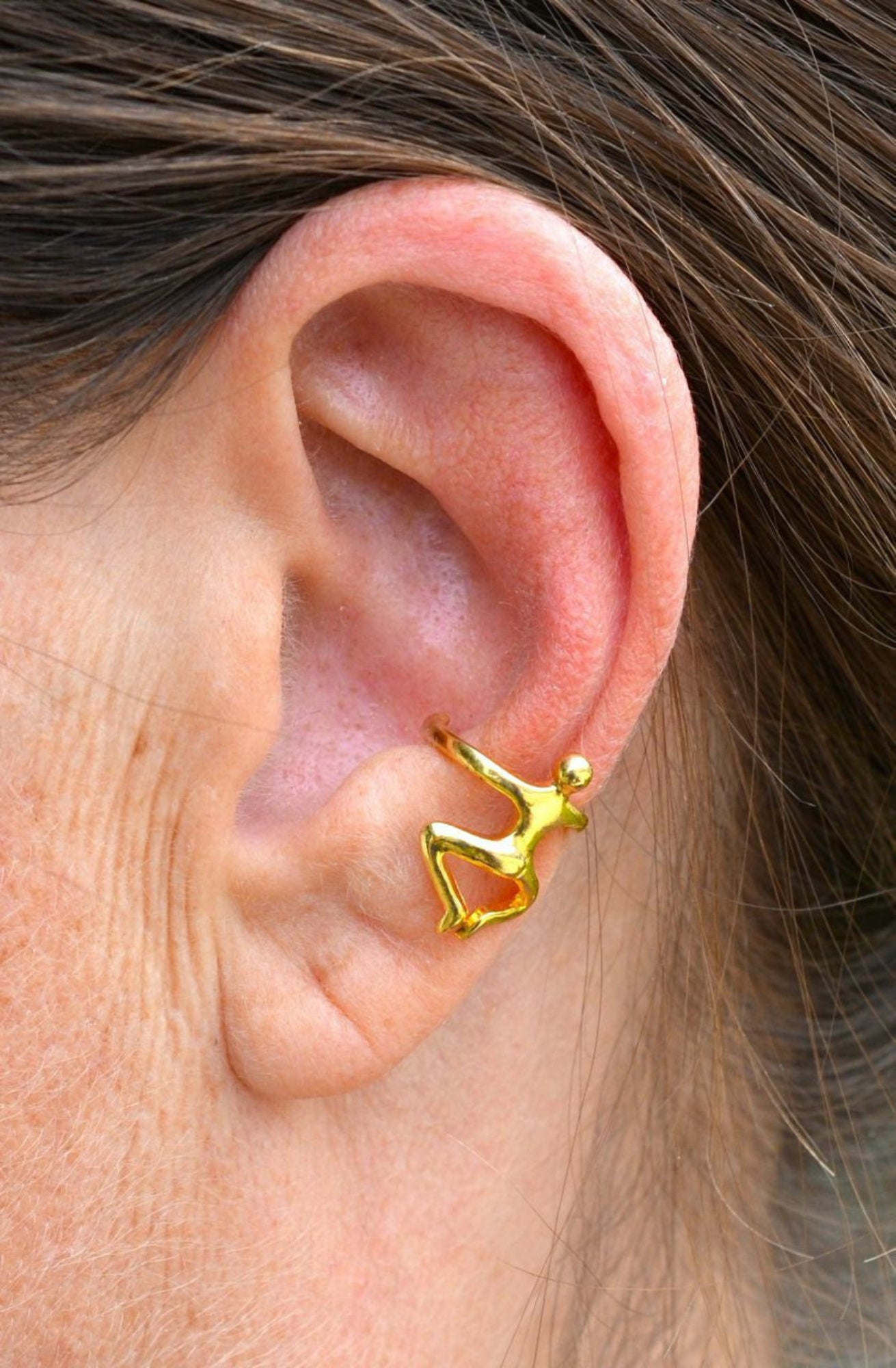 gold climbing man ear cuff worn on ear non piercing earring side view