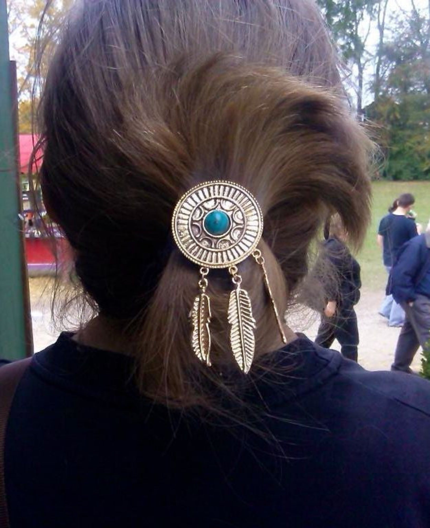 Model wearing gold dream catcher hair hook with turquoise stone and feather charms