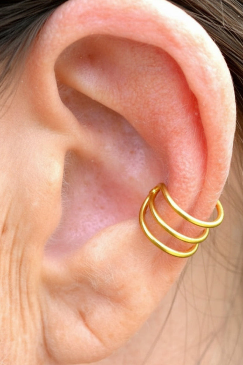 Model wearing gold triple strand non-piercing ear cuff on outer ear