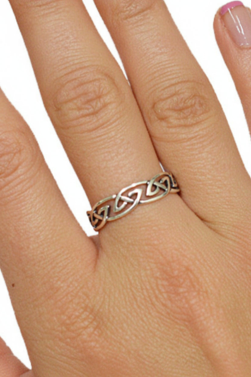 Model wearing Celtic barbed wire ring in sterling silver with interwoven knot design
