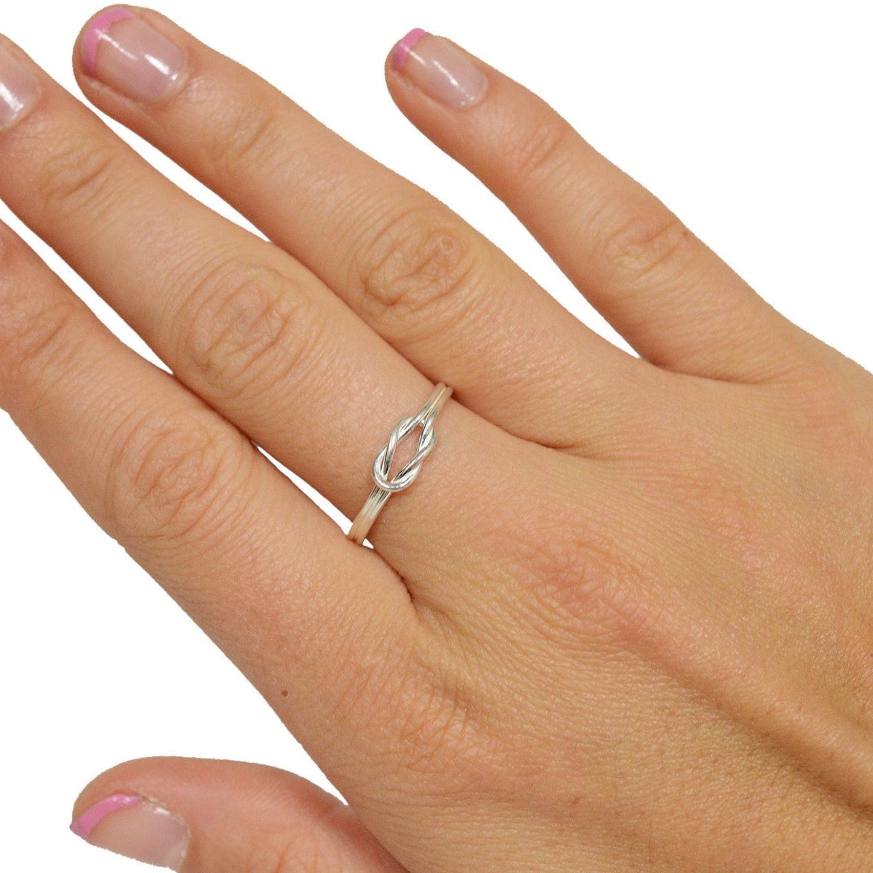 Model wearing Heracles knot sterling silver knot ring on finger, intertwined band design
