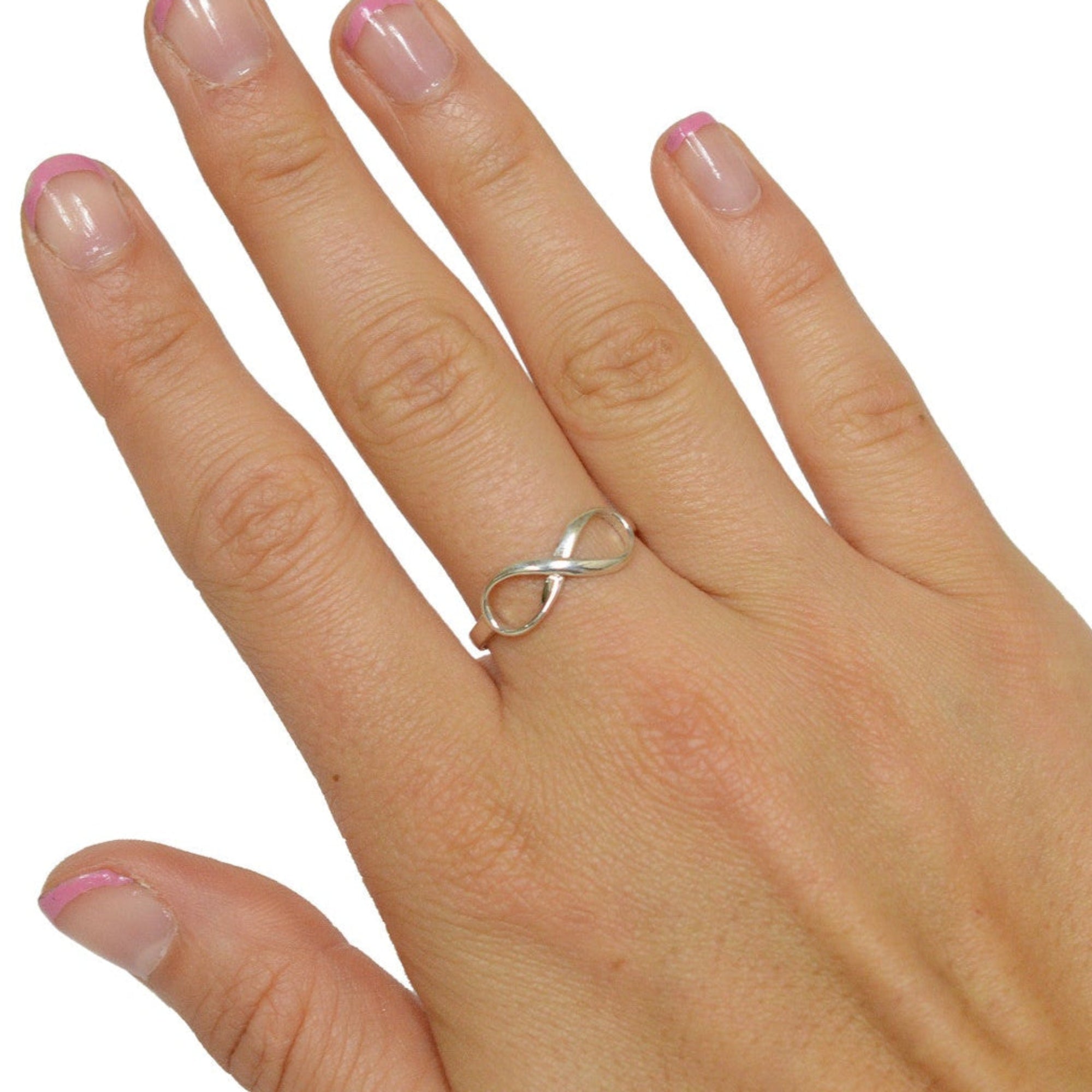 Model wearing infinity ring in sterling silver with infinity symbol design, minimalist ring on hand, front view