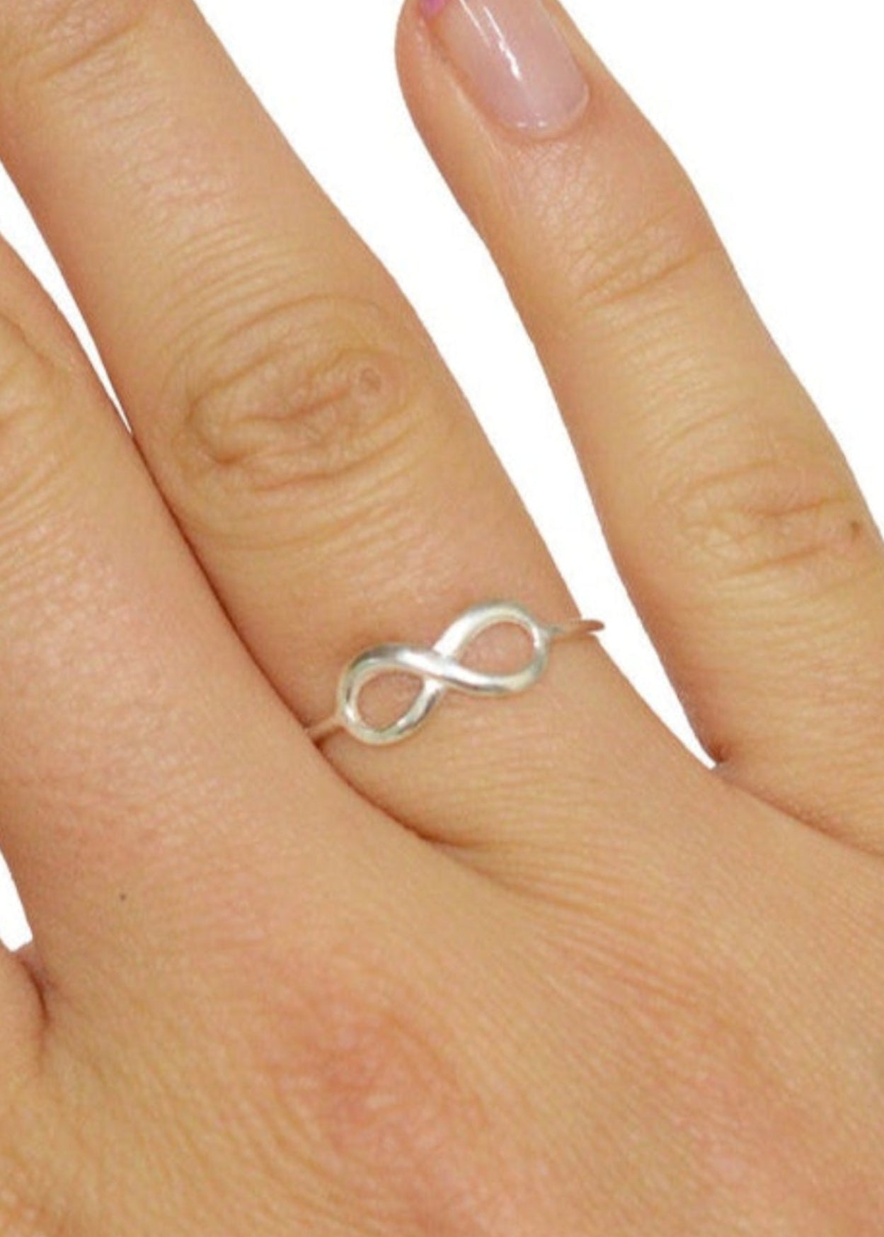Model wearing infinity thin band ring in sterling silver, minimalist infinity symbol design, front view on hand