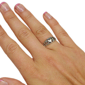 Hand wearing sterling silver heart and flower band ring
