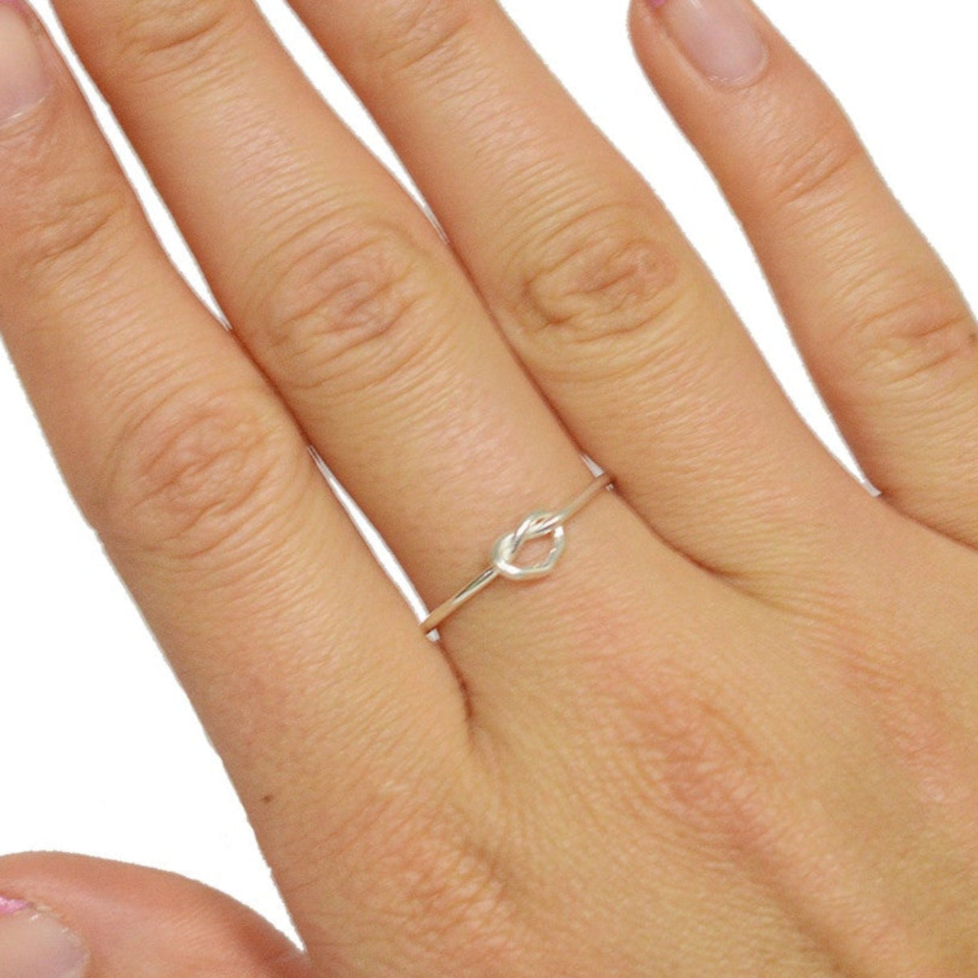 model wearing open heart ring in sterling silver, minimalist romantic design, front view on hand
