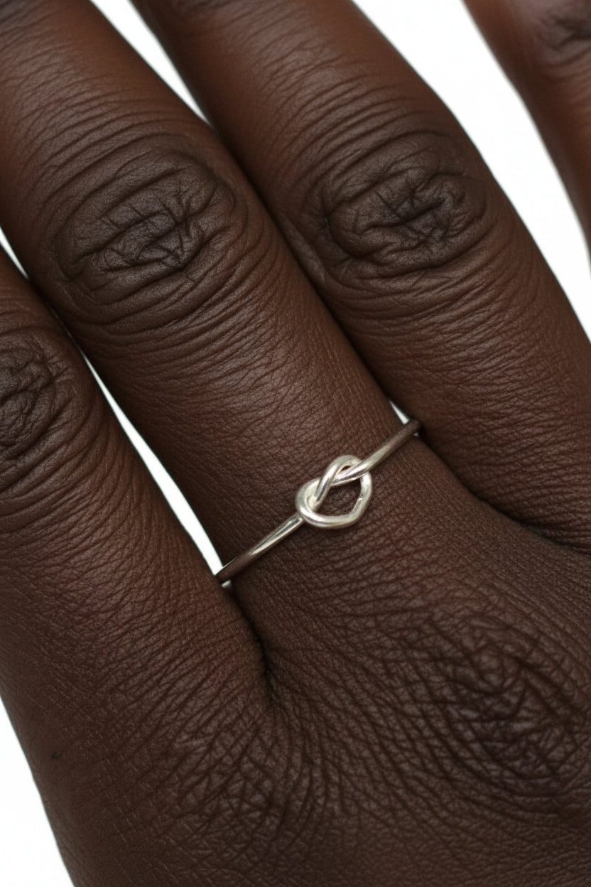 model wearing open heart ring in sterling silver, minimalist romantic design, front view on hand