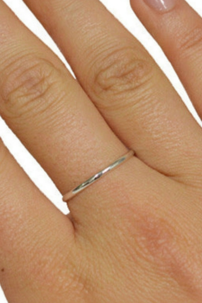 Thin sterling silver band ring worn on finger