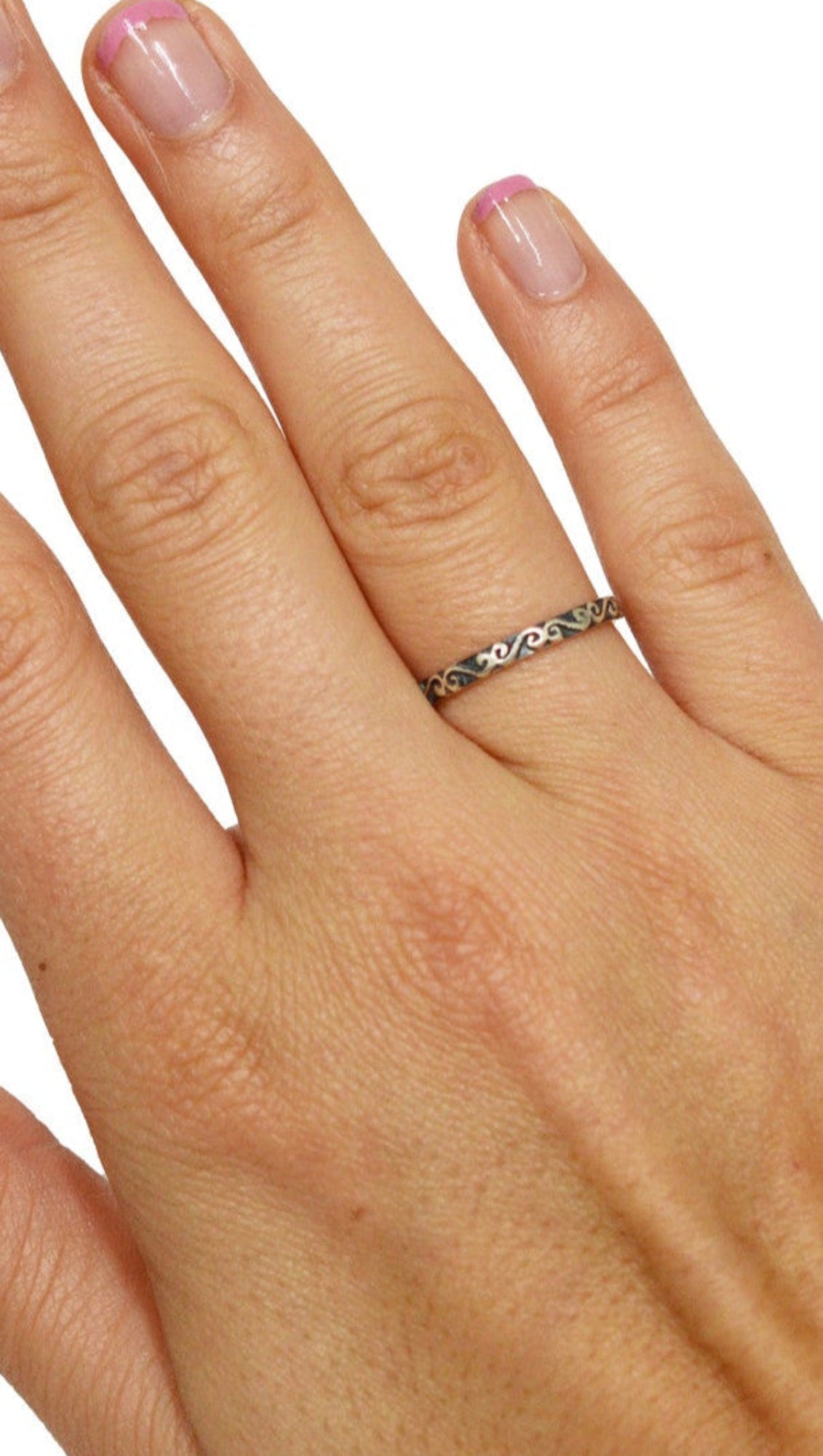 Model wearing Whispered Secret ring in sterling silver with Celtic spiral band design, on hand, front view