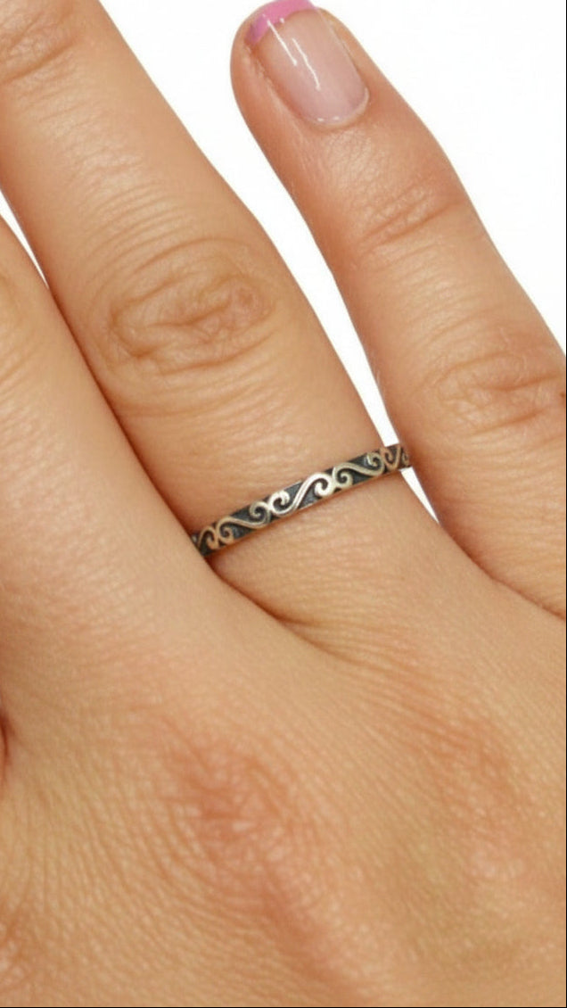 Model wearing Whispered Secret ring in sterling silver with Celtic spiral band design, on hand, front view