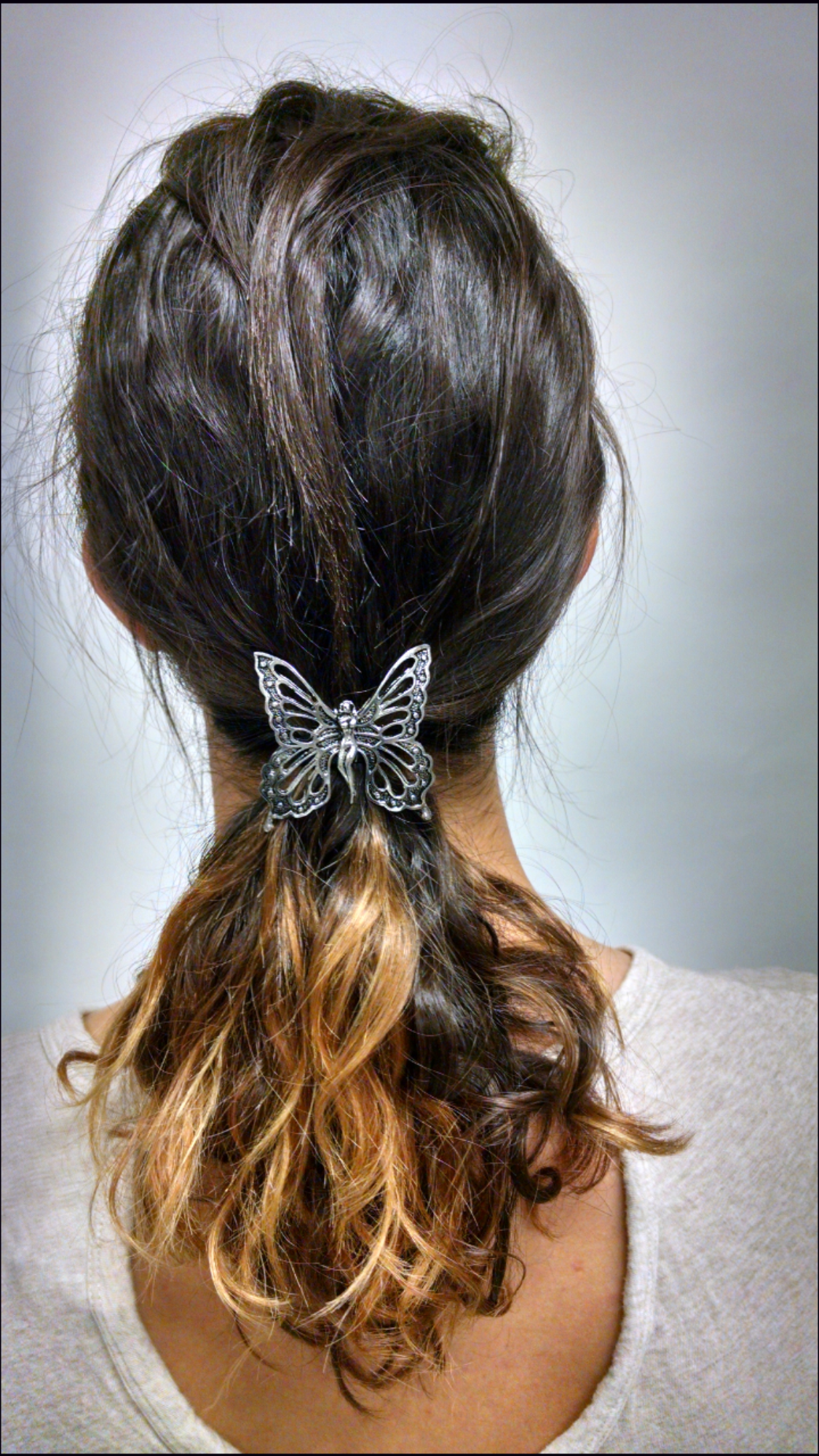 Silver butterfly ponytail hair hook securing ponytail, back view