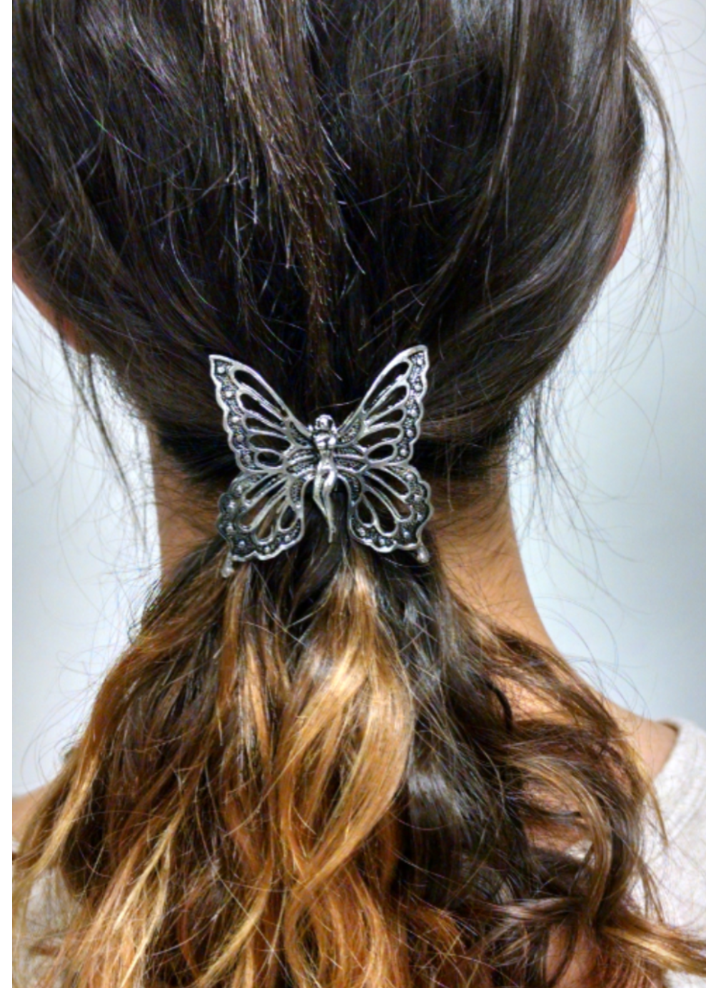 Silver butterfly ponytail hair hook securing ponytail, back view
