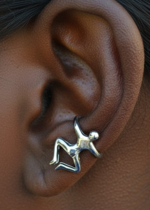 silver climbing man ear cuff on ear close up minimalist figure jewelry