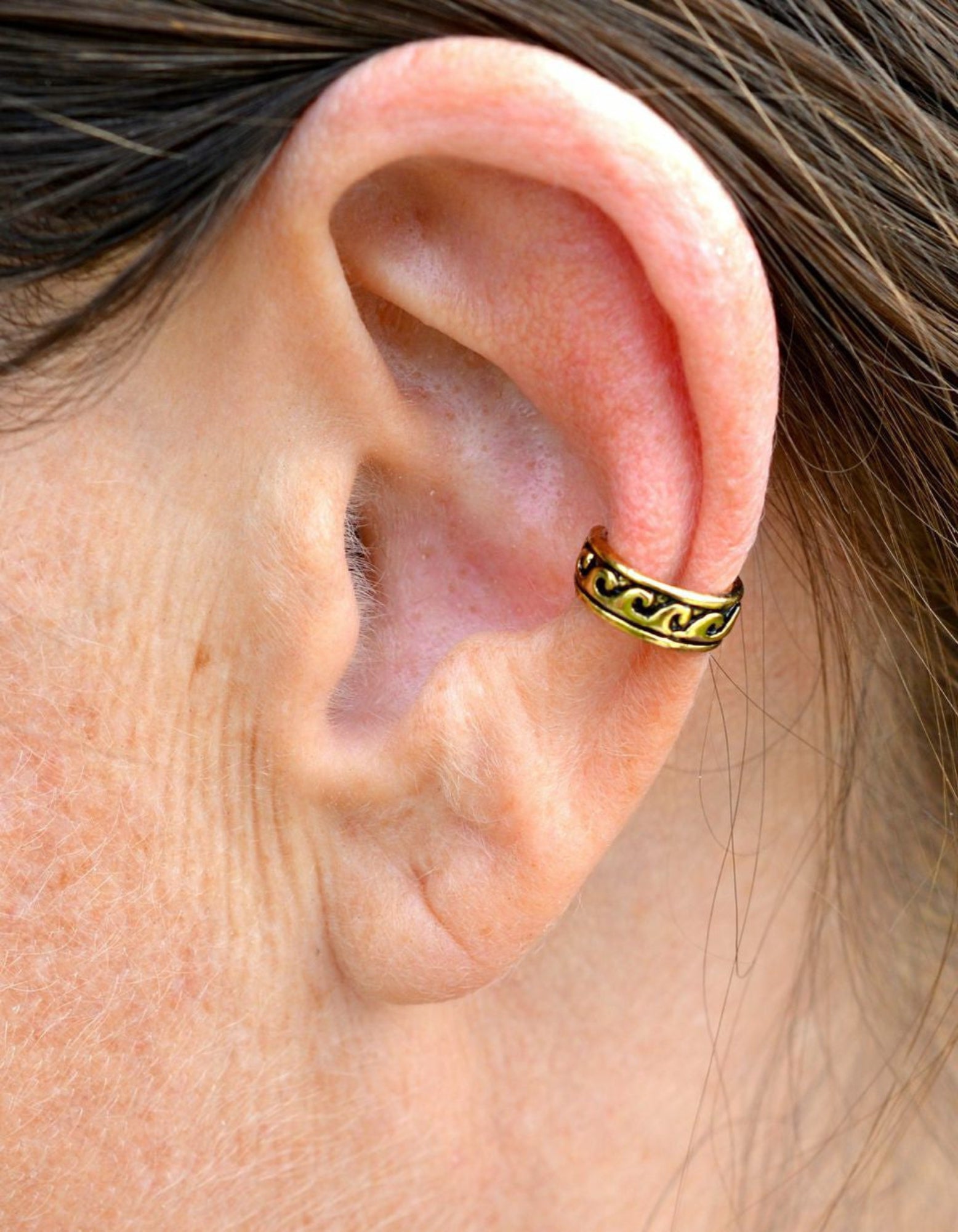 gold ear cuff with black wave pattern non piercing adjustable earring front view