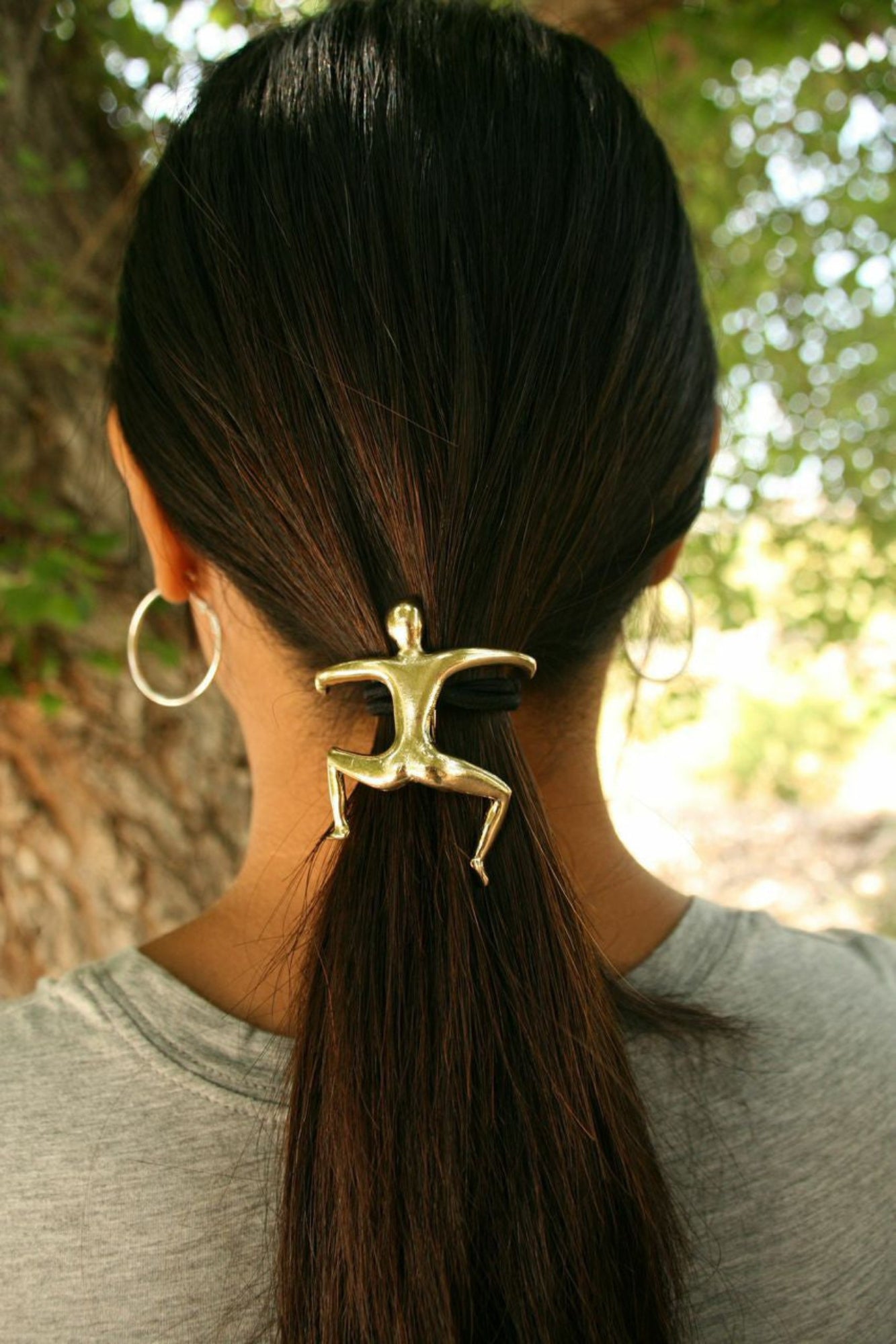 Gold Hang Man ponytail hair hook securing ponytail, back view