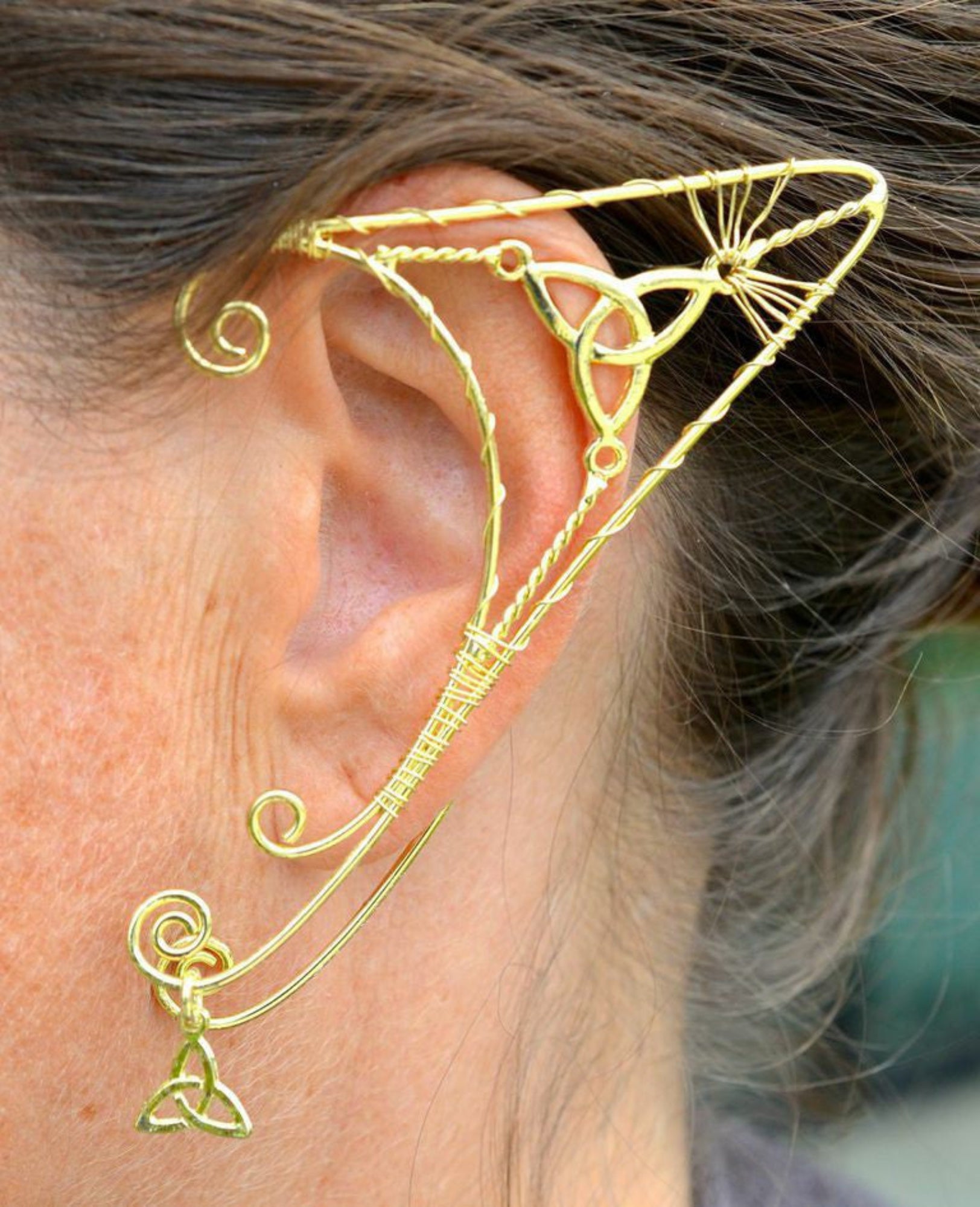 gold elf ear cuff worn on ear trinity knot wire wrap non piercing ear jewelry side view
